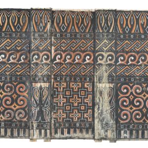 An authentic antique Toraja tribal wood carving panel from Sulawesi, featuring hand-painted geometric motifs, traditional spirals, and stylized buffalo head carvings in red, black, and white.